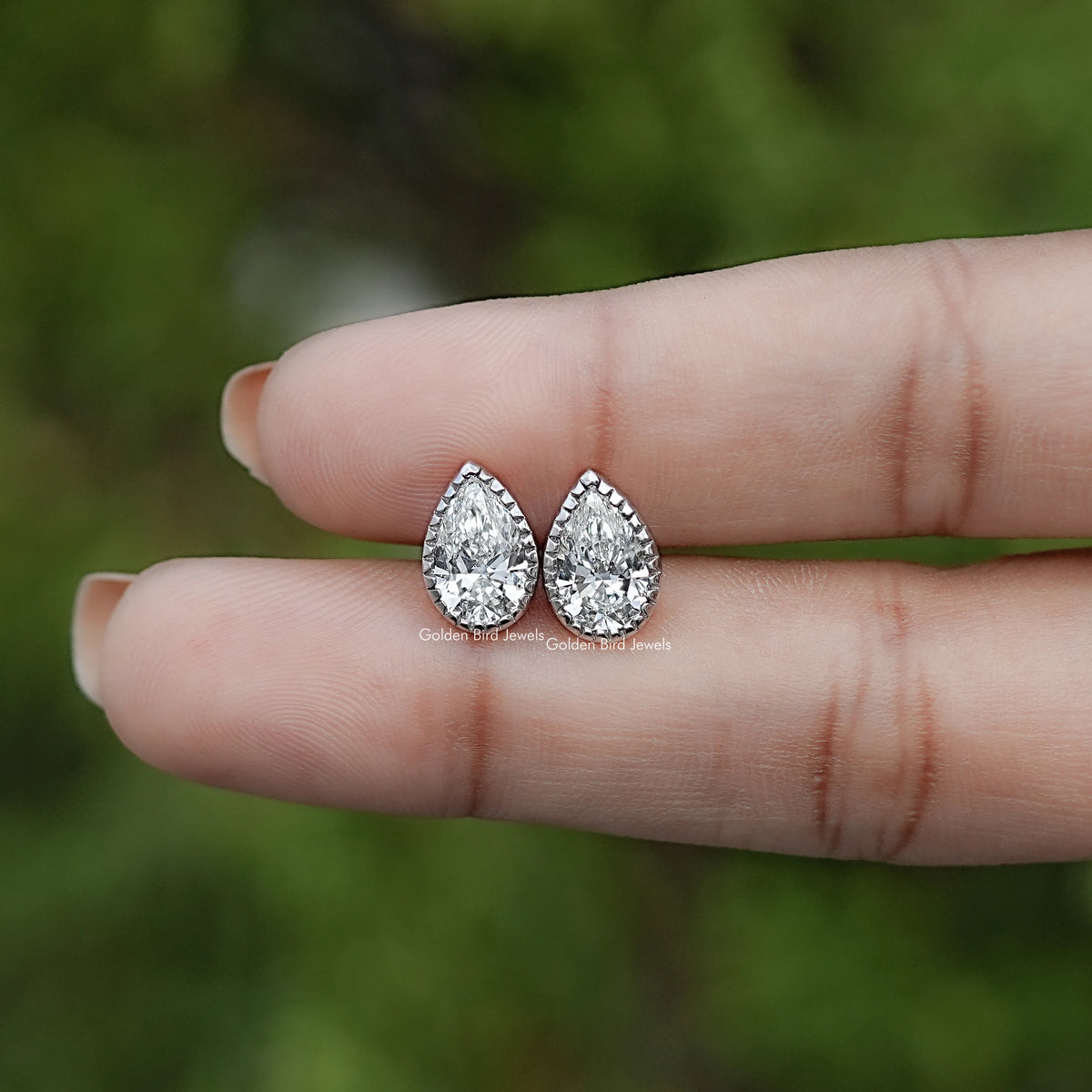 In Hand View Of Pear Cut Lab Diamond Bezel Studs