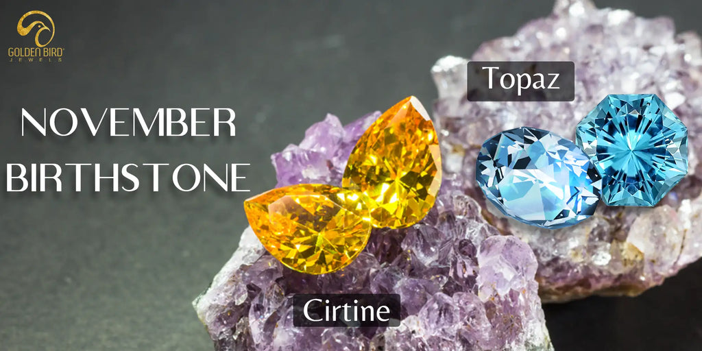 [An image showing two November birthstones a pair of vibrant golden yellow citrine gemstones and a pair of sparkling blue topaz gemstones both displayed on a bed of amethyst crystals with the text November]-[golden bird jewels]