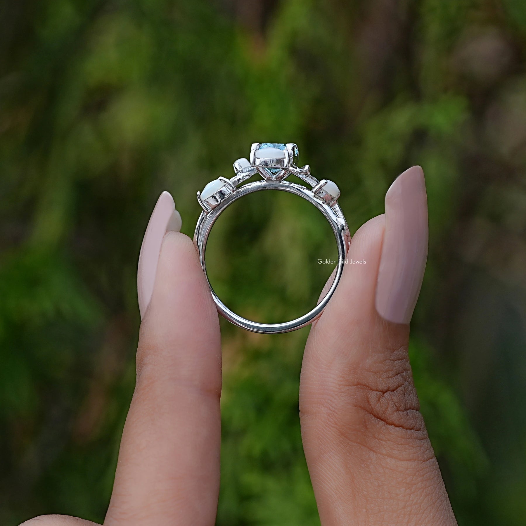 Back View of Oval Aquamarine Gemstone Leaf Ring In two fingers