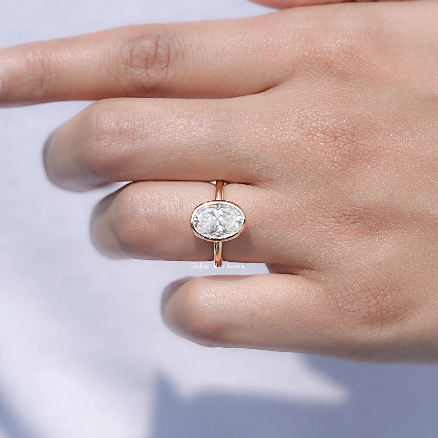 In finger front view of Oval Moissanite Halo Engagement Ring in unique shape
