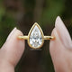 Bezel Set Pear Cut Lab Diamond Solitaire Ring In Two Fingers
