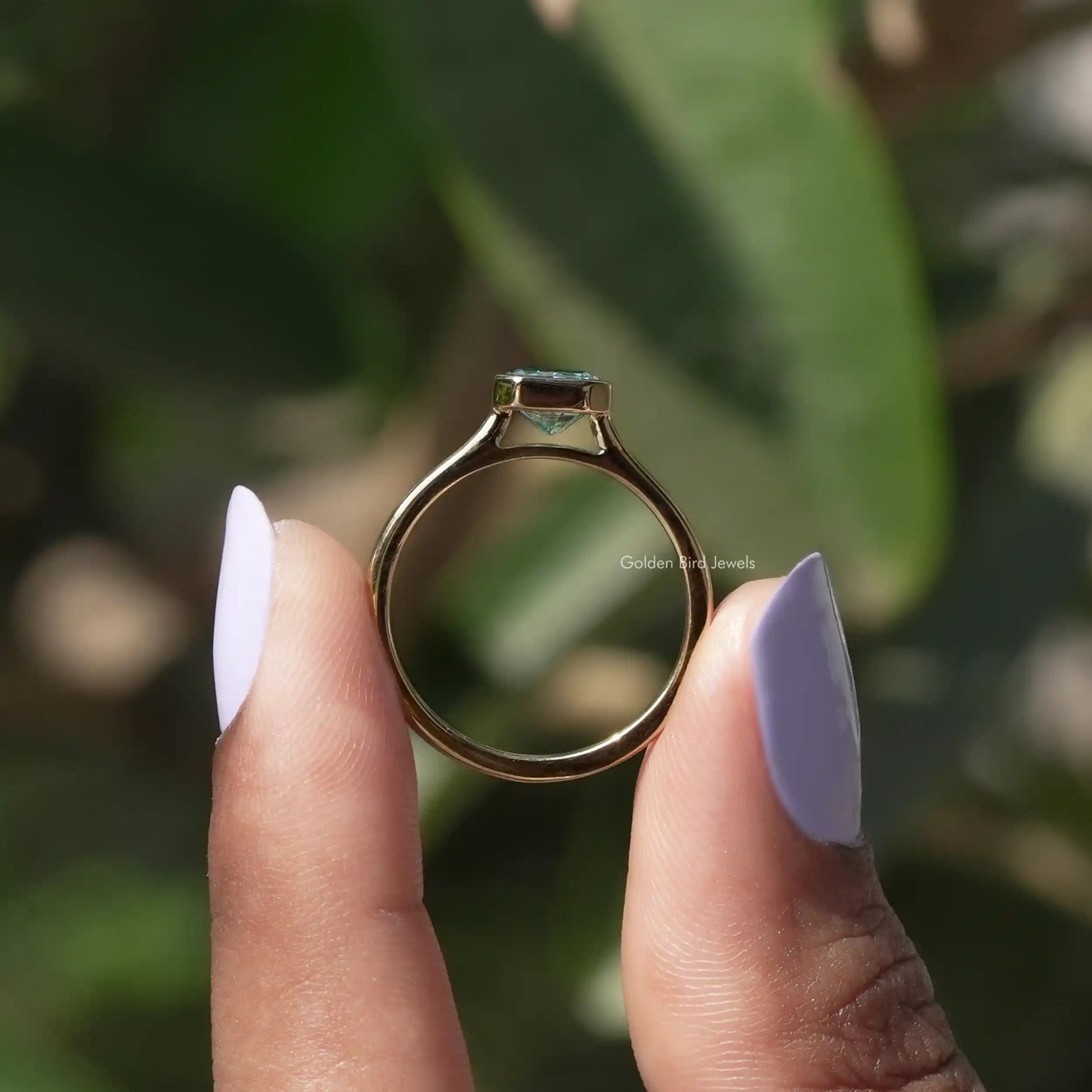 Back View of Radiant Cut Bezel Set Engagement Ring In two fingers