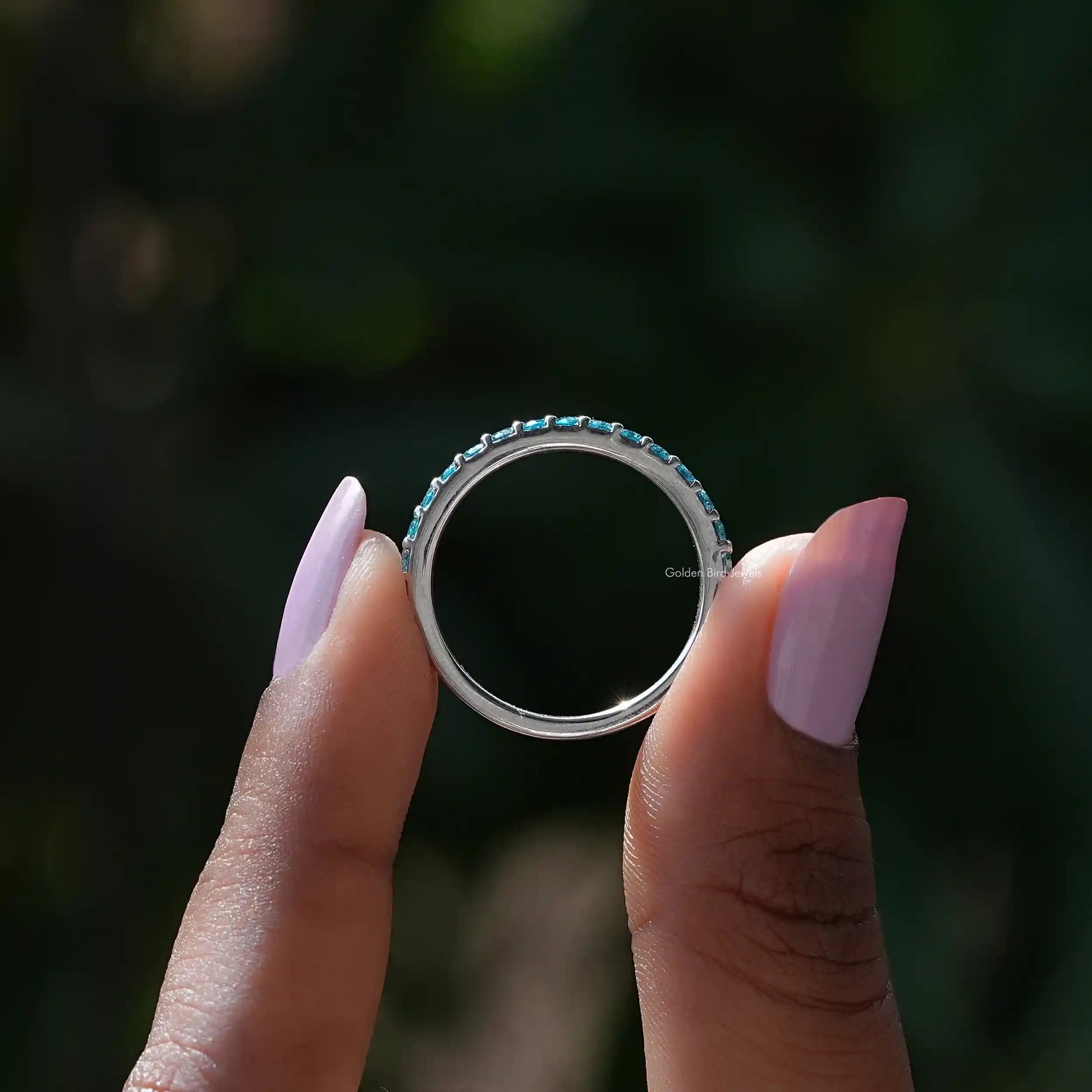 Back view of Blue Topaz Round Eternity Band in secure setting