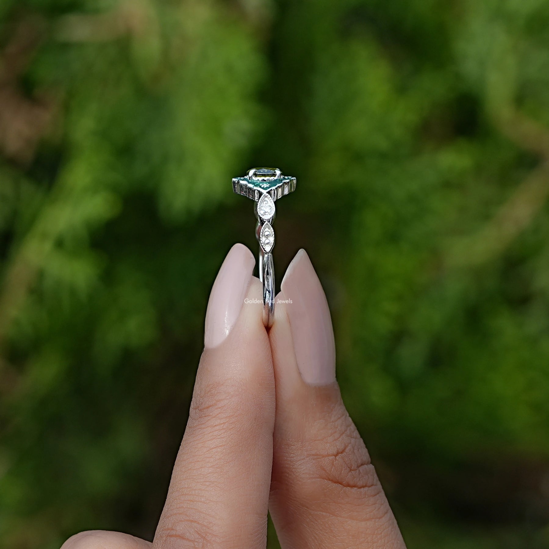 Side View of East West Oval Cut Gemstone Engagement Ring In two fingers