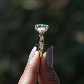 Side View of Green Cushion Cut Moissanite Accent Stone Ring In two fingers