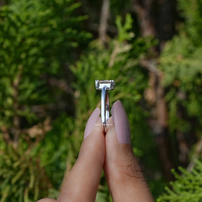 Side View of Orange Emerald Cut Gemstone Ring In two fingers