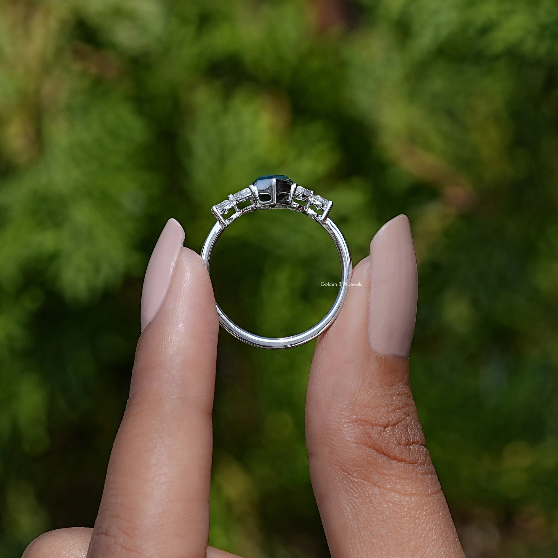 Back View of Emerald Green Hexagon Cut Gemstone Ring In two fingers