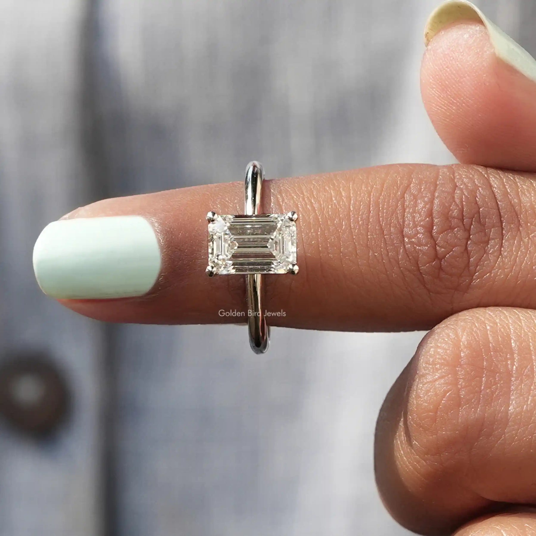 In finger front View of Emerald Cut Diamond Solitaire Ring