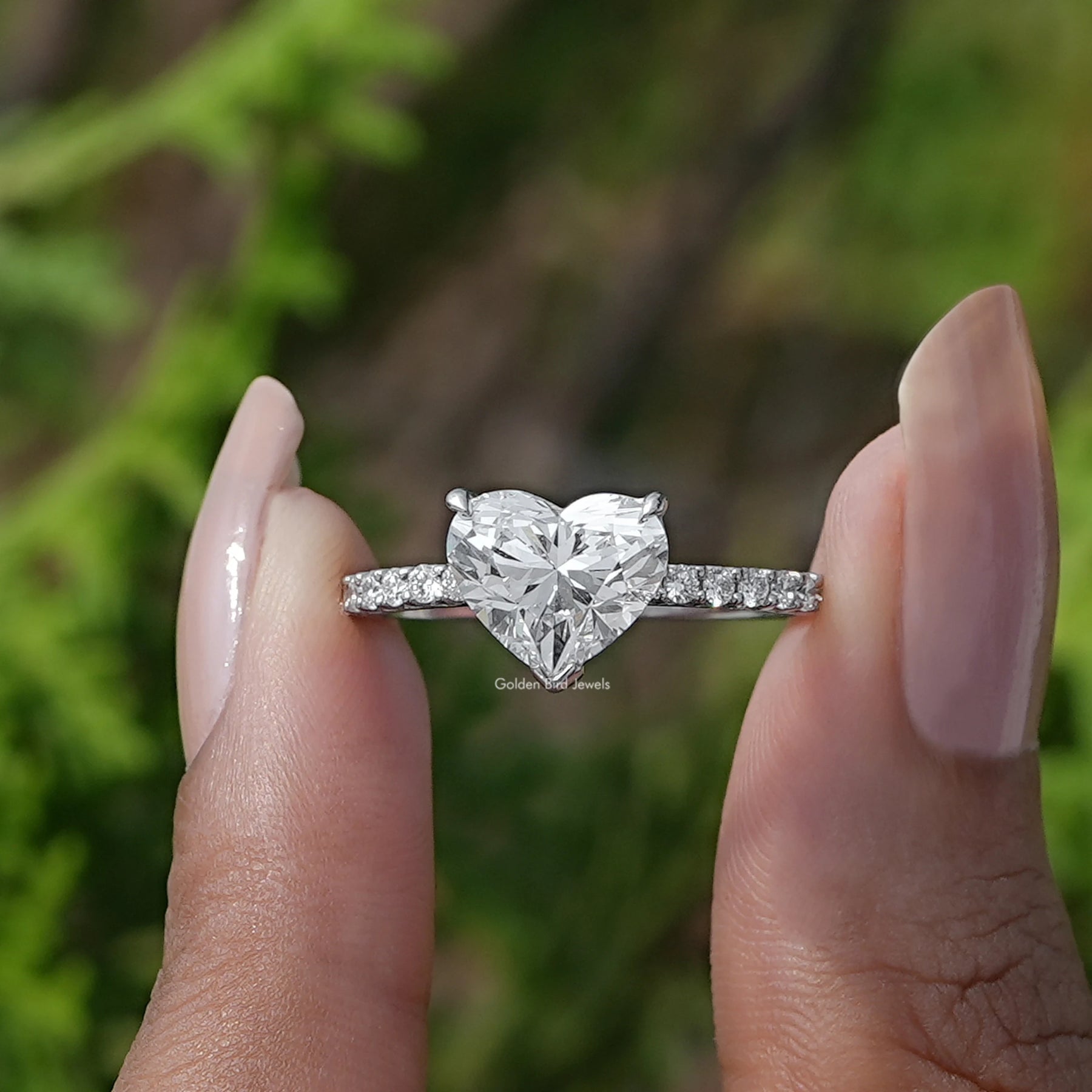 Front View of Heart Cut Solitaire Accent Diamond Ring In two fingers