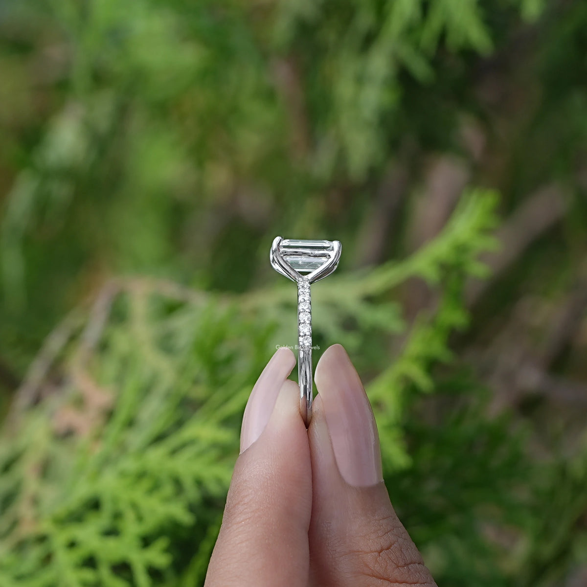 Side View of Emerald Cut Solitaire Accent Diamond Ring In two fingers