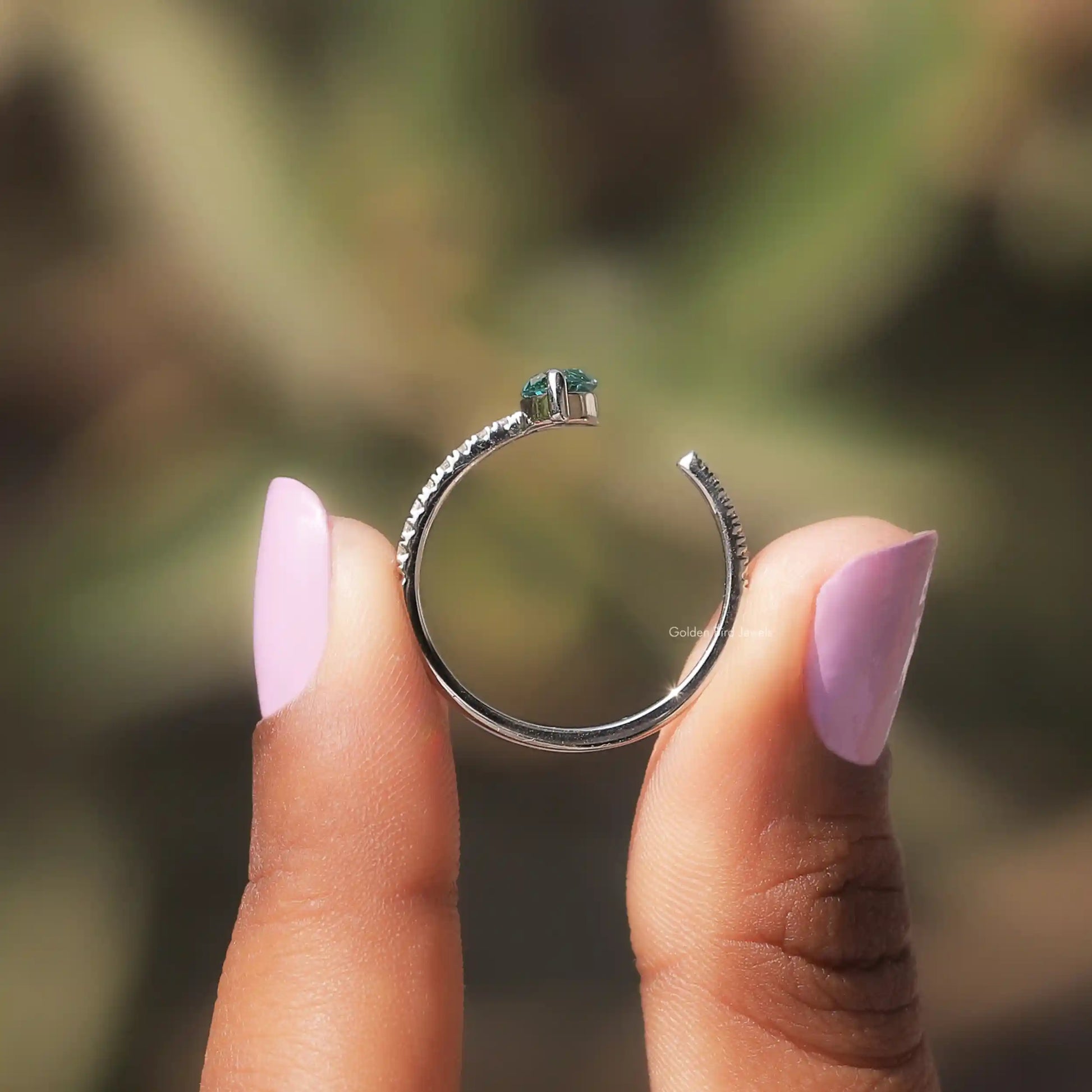 Back View of Green Marquise Cut Accent Stone Ring In two fingers