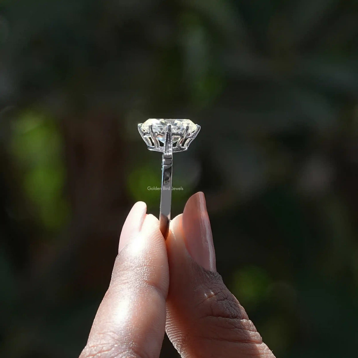 Side View of Moissanite Oval Cut Accent Stone Ring In two fingers