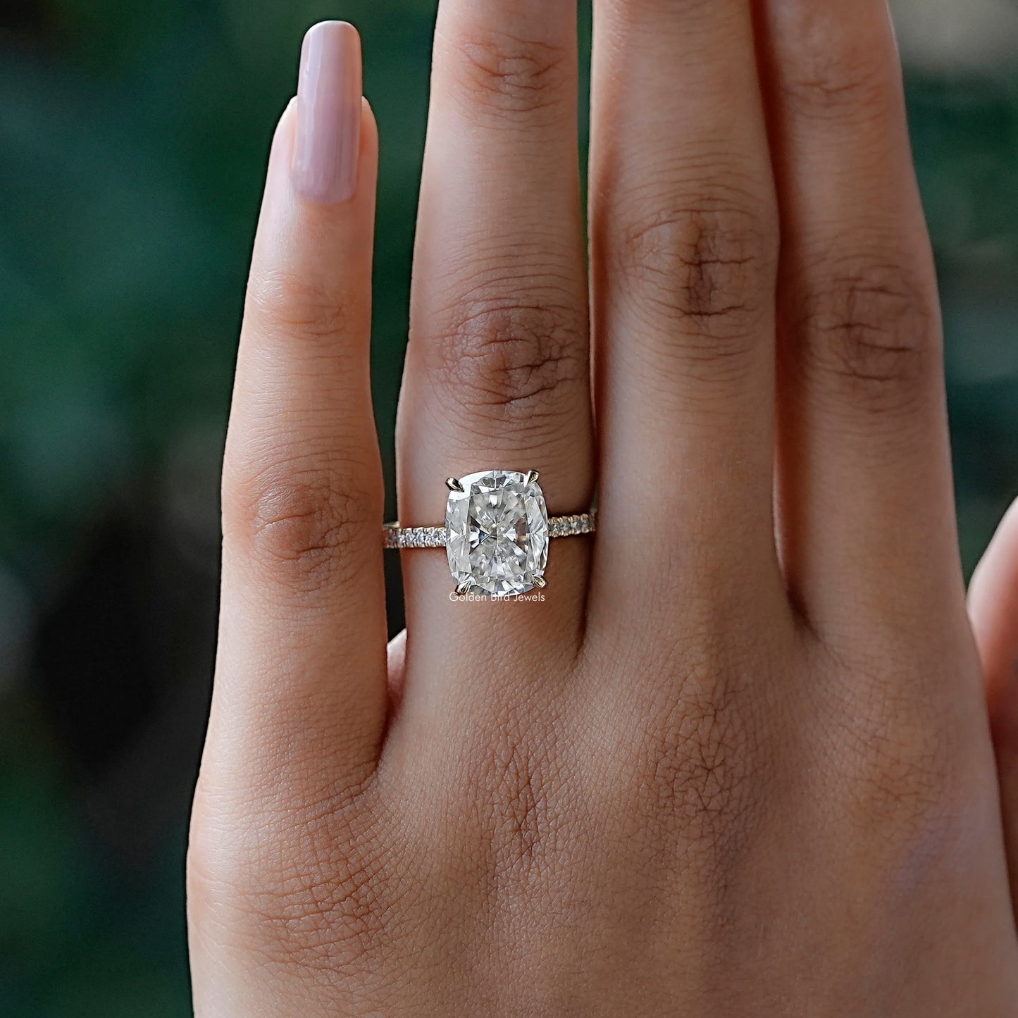 In finger front view of halo cushion moissanite engagement ring 