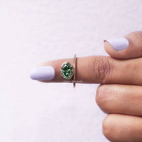 In finger front View of Dark Green Oval Cut Moissanite Ring