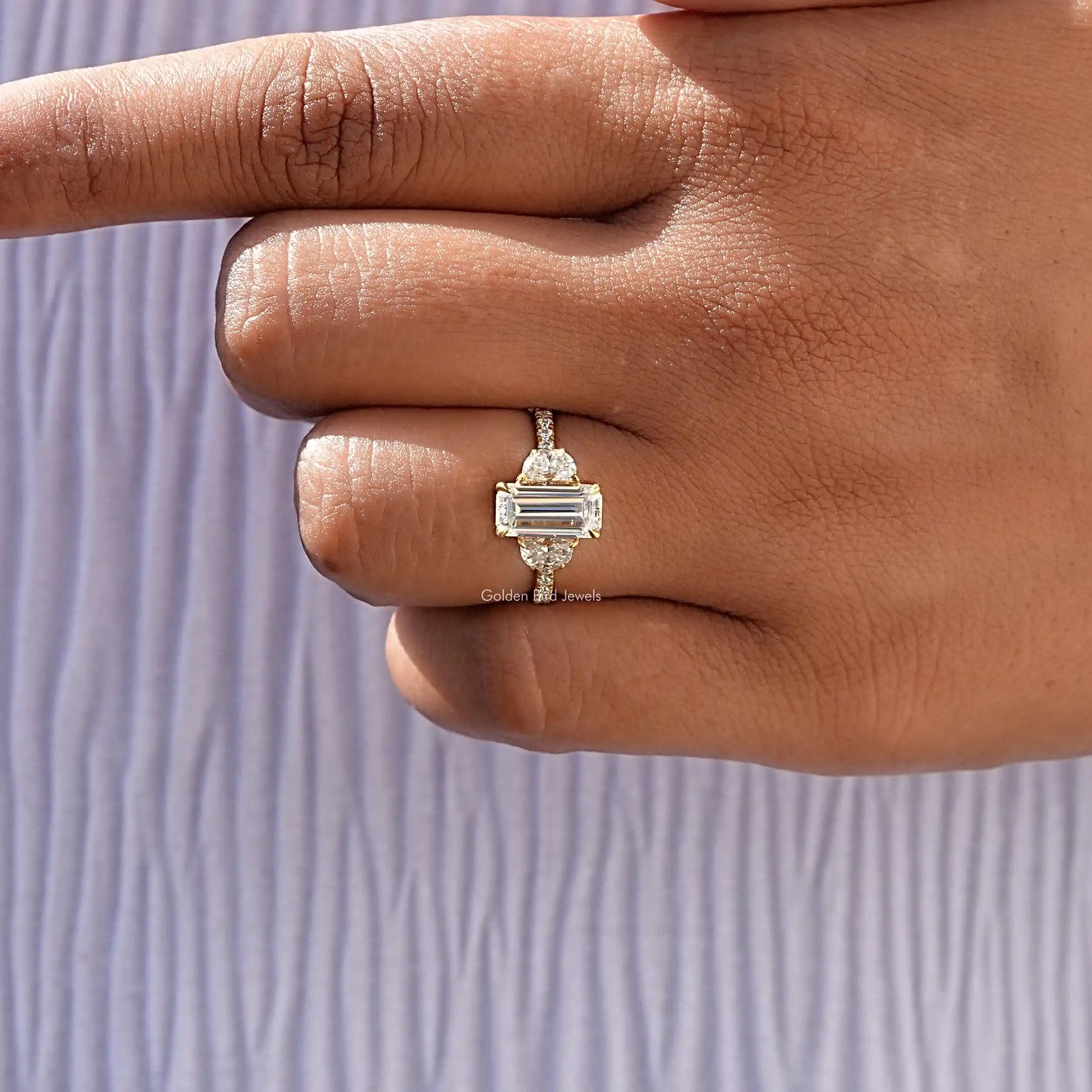 View of Moissanite Long Emerald Cut Three Stone Ring In finger