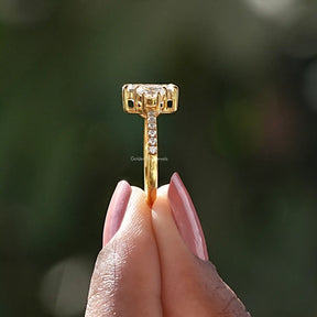 Side View of Emerald Cut Engagement Ring In two fingers