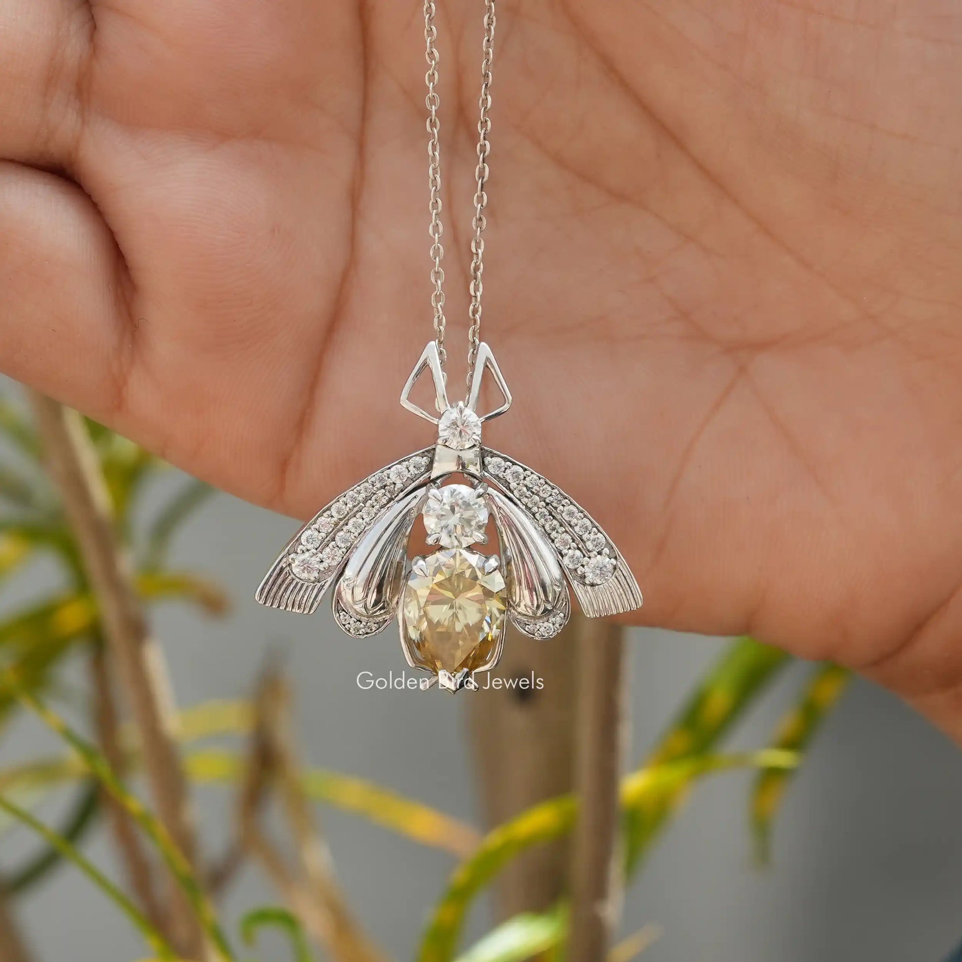 In hand showing view of moissanite pendant	 		