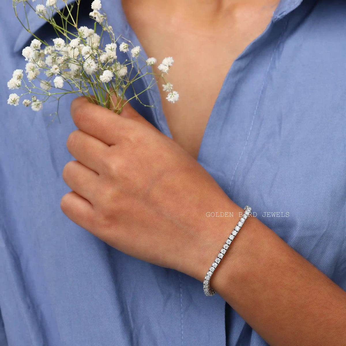 In hand front view of round cut moissanite tennis bracelet crafted with white gold