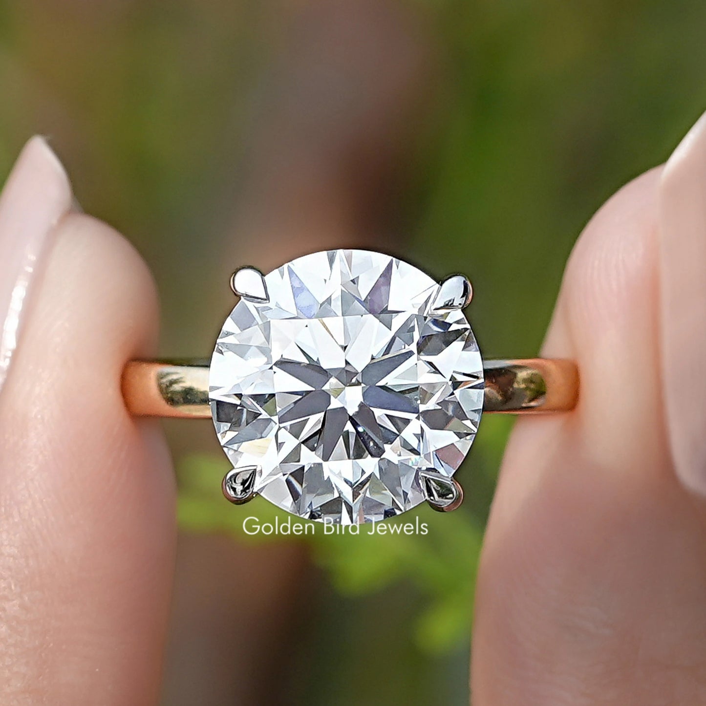 Round Cut Lab Grown Diamond Solitaire Ring Held Between Fingers