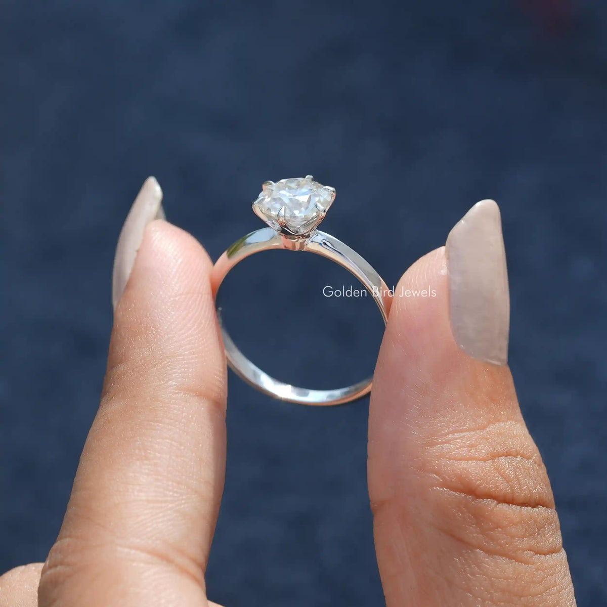 Back View of Moissanite OEC Round Cut Proposal Ring In two fingers