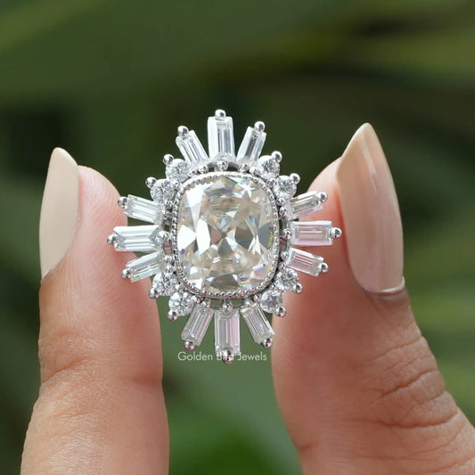 Two fingers holding the Old Mine Cushion Cut Moissanite Halo Engagement Ring 
