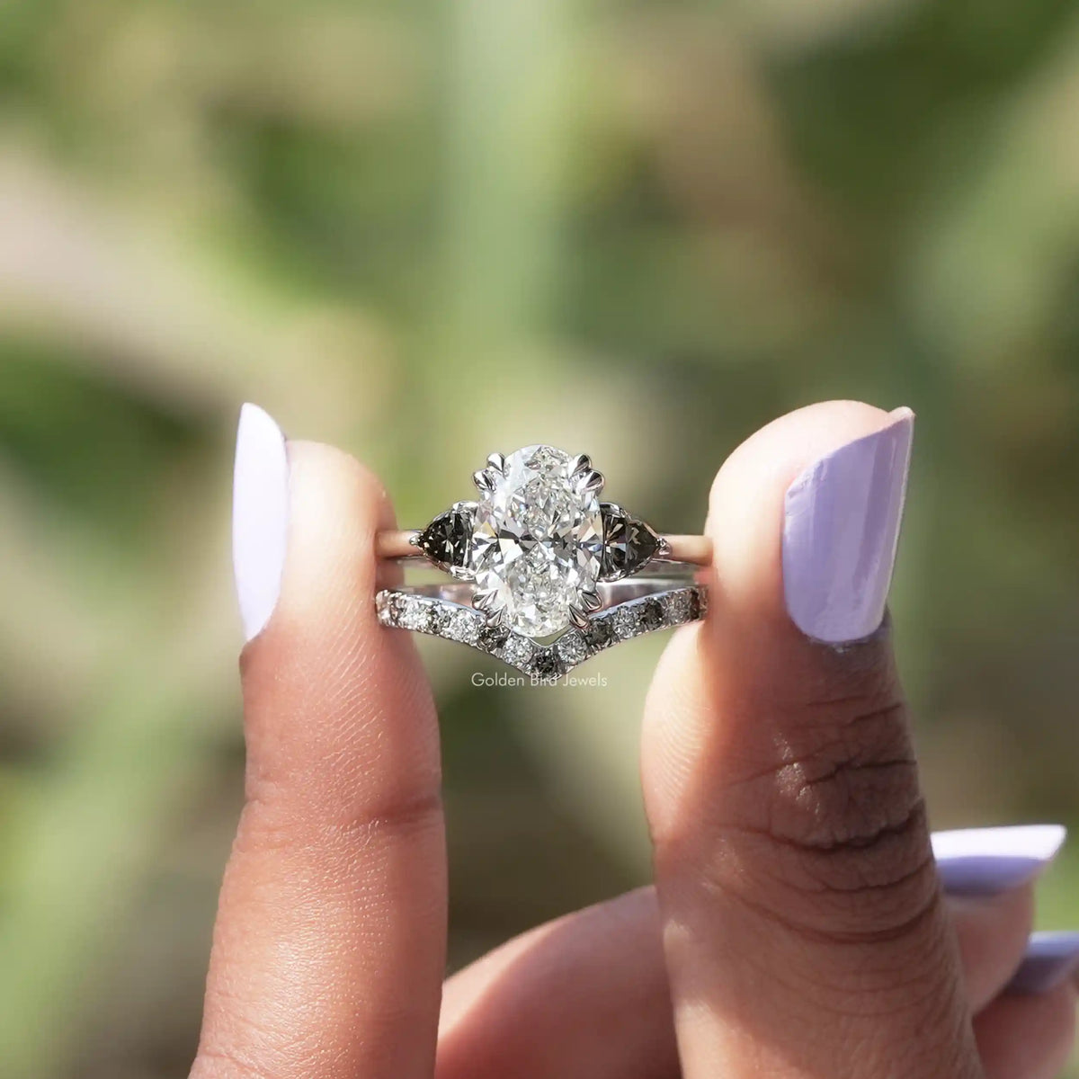 Two fingers holding the Oval Cut Lab Grown Diamond Bridal Set