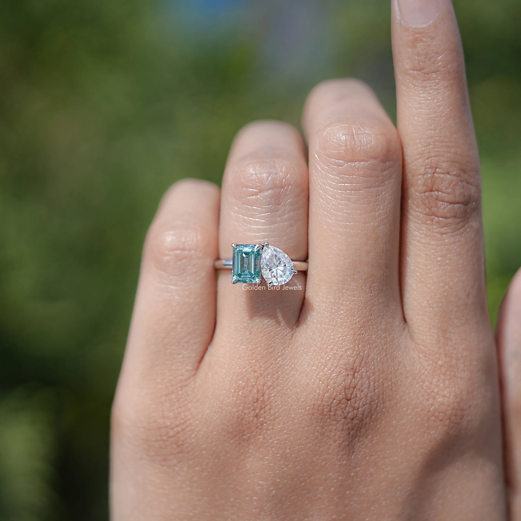 In finger view of Pear And Emerald Cut Moissanite Solitaire Ring	