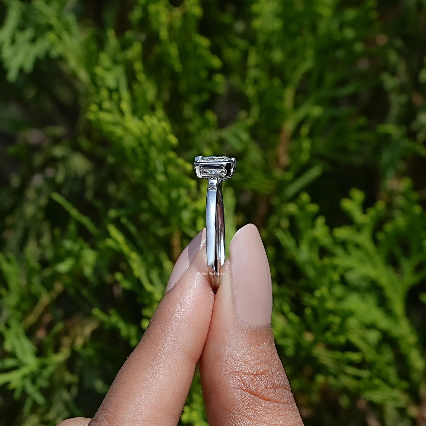 Side View of Pear And Radiant Cut Toi Et Moi Ring In two fingers