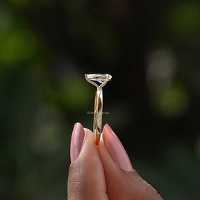 Side View of Pear Cut Diamond Solitaire Engagement Ring In two fingers