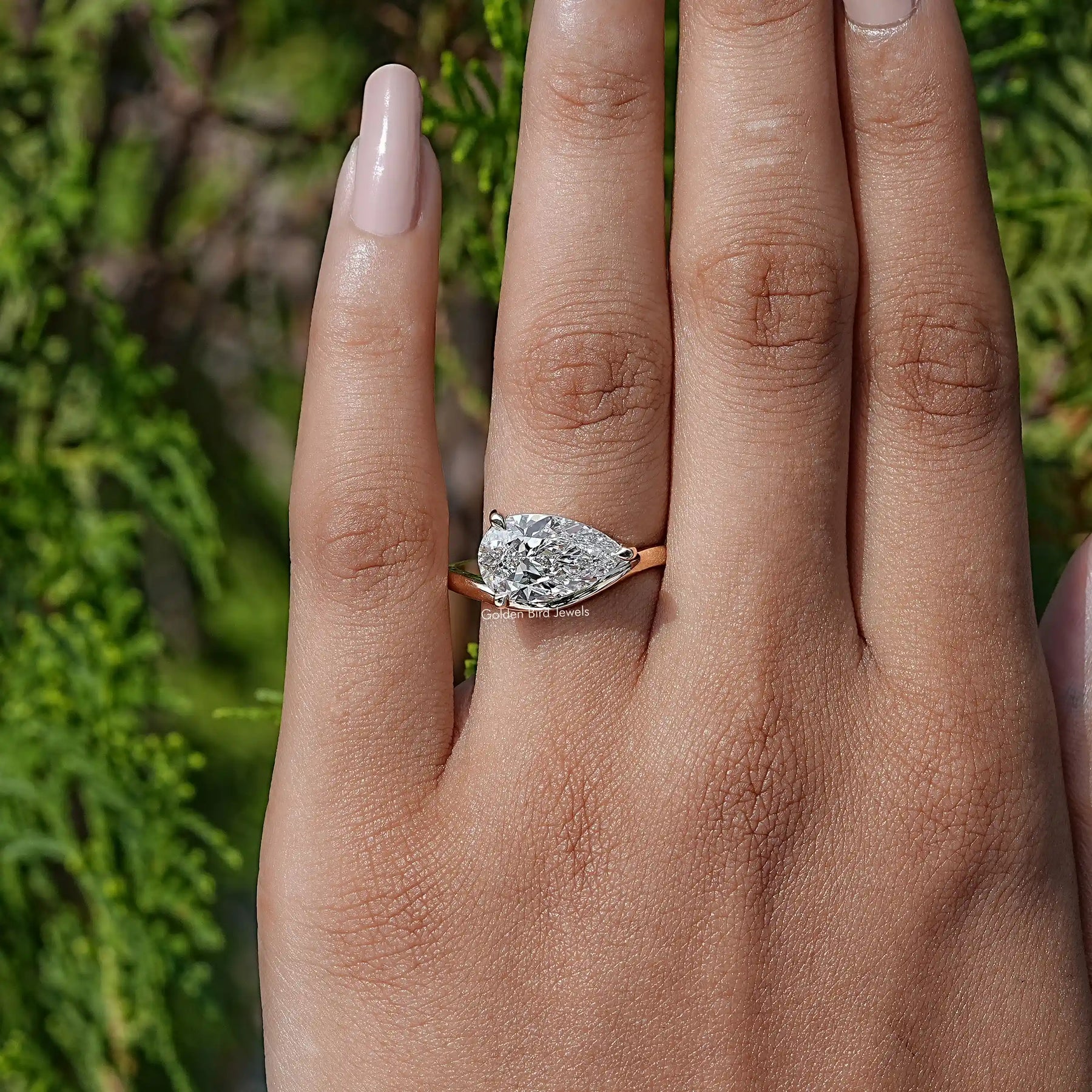 In finger view of Pear Lab Diamond Curved Solitaire Ring
