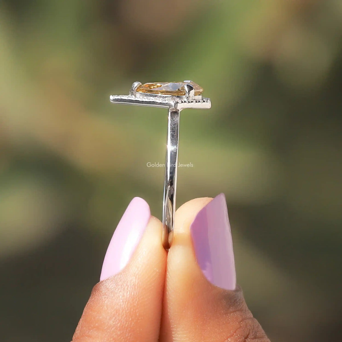 Side View of Pear Cut Moissanite Engagement Ring In two fingers