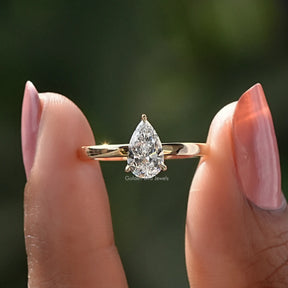 Two fingers holding the Pear Cut Diamond Solitaire Ring