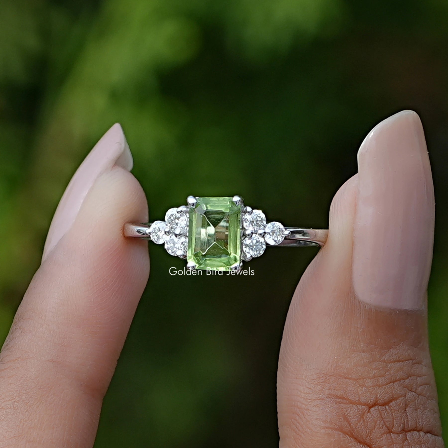 Front View of Peridot Green Emerald Gemstone Ring In two Fingers