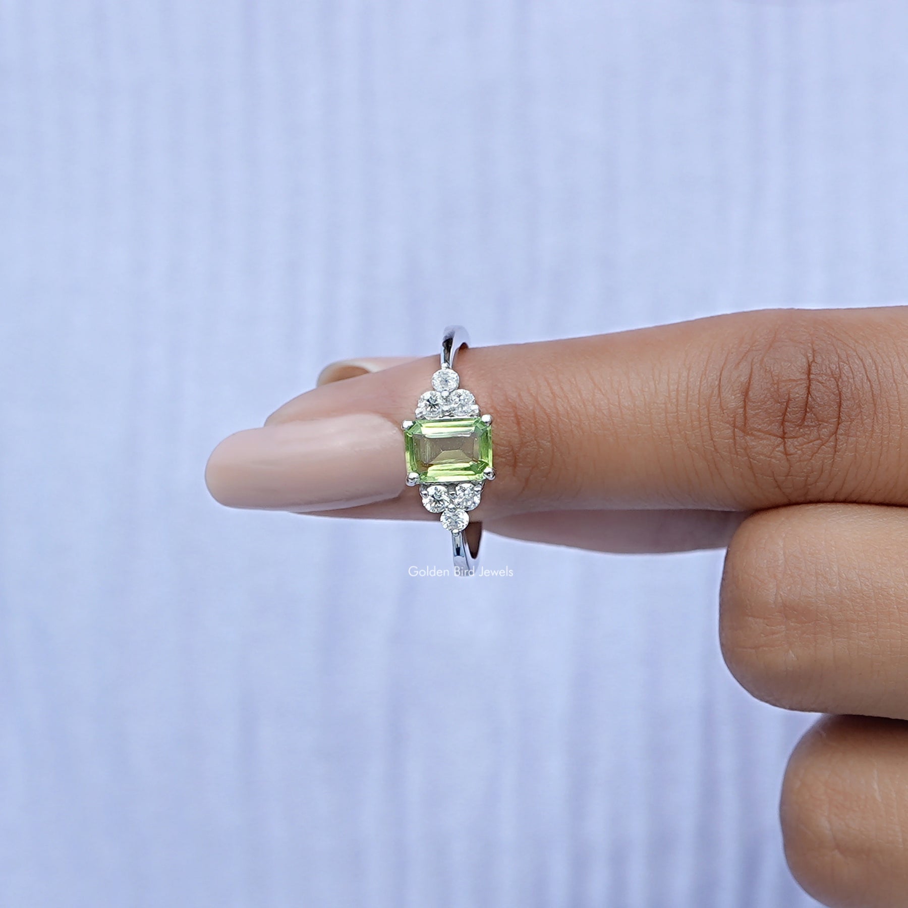 In finger front View of Green Emerald Cut Gemstone Ring In White Gold