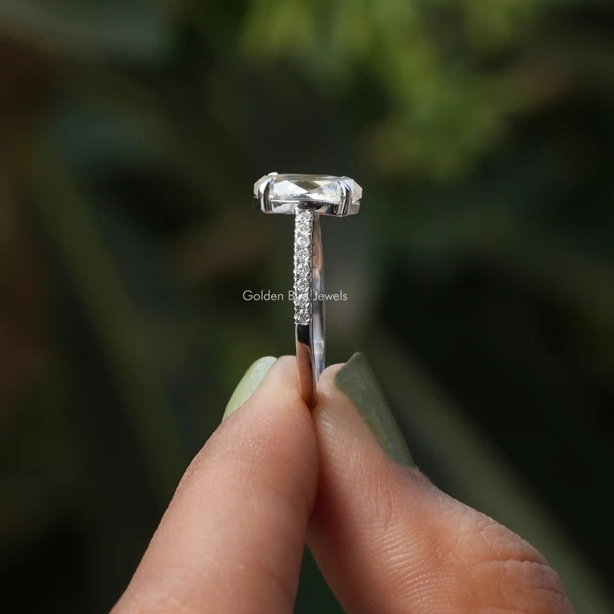 Side View of Moissanite Oval And Round Cut Ring In two fingers