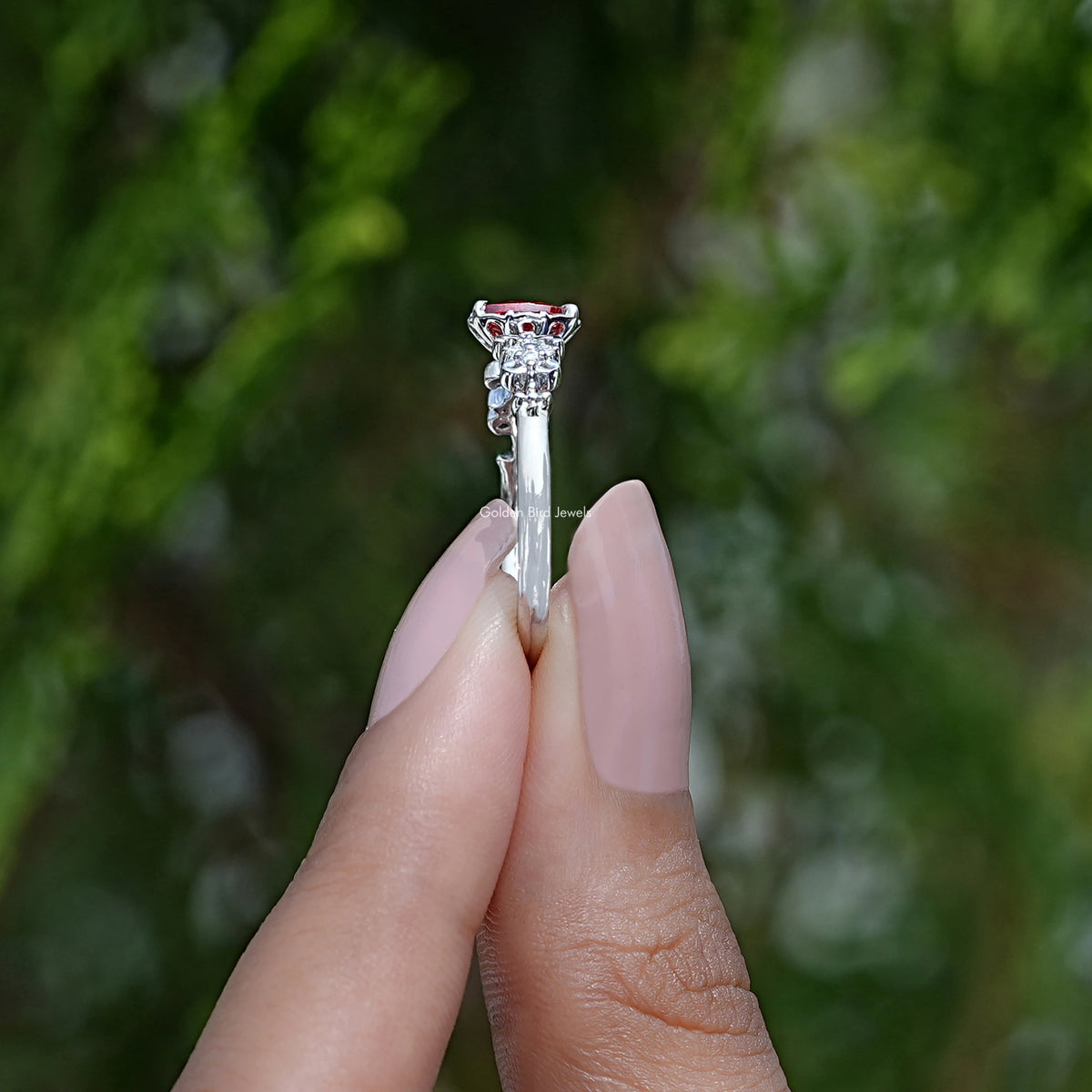 Side View of Emerald Cut Gemstone Engagement Ring In two fingers