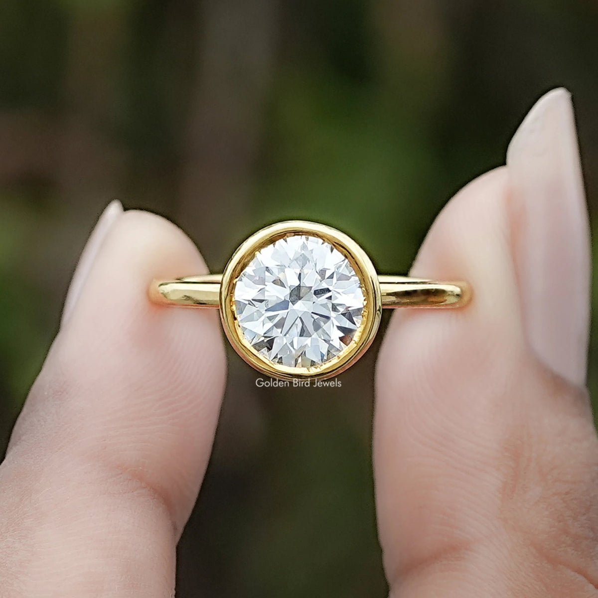 Round Cut Lab Diamond Bezel Set Ring Between Two Fingers