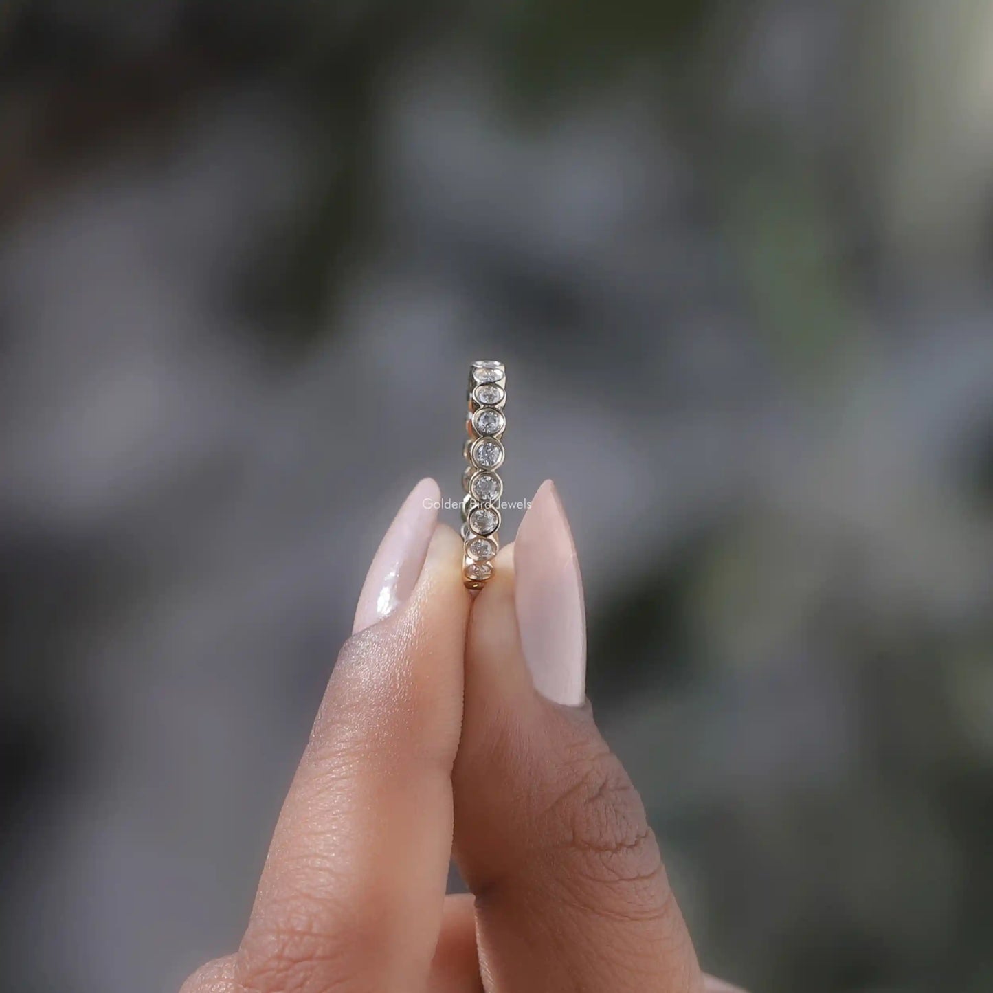 Side View of Round Cut Bezel Set Full Eternity Band In two fingers