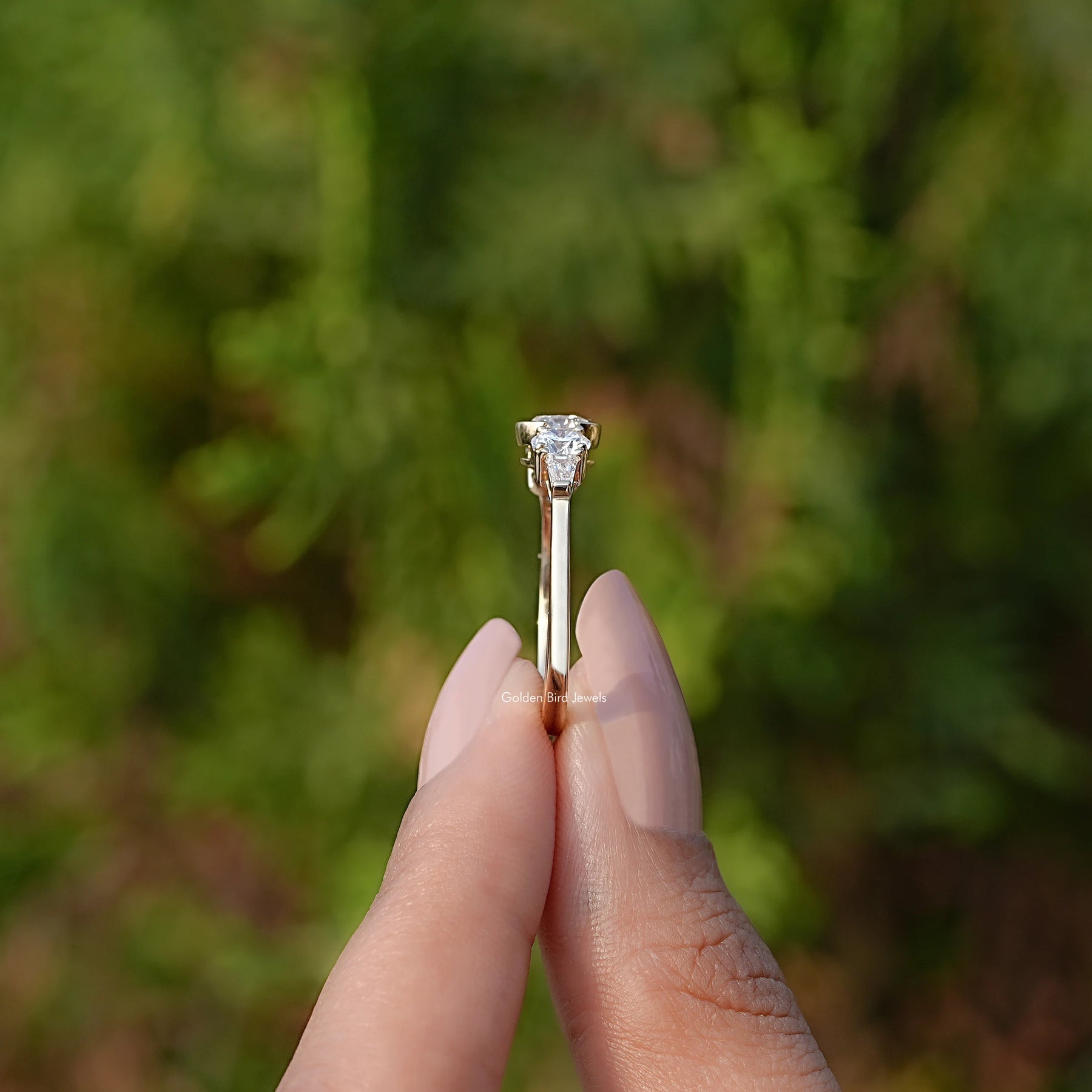 Side View of Round Cut Lab Diamond Engagement Ring In two fingers