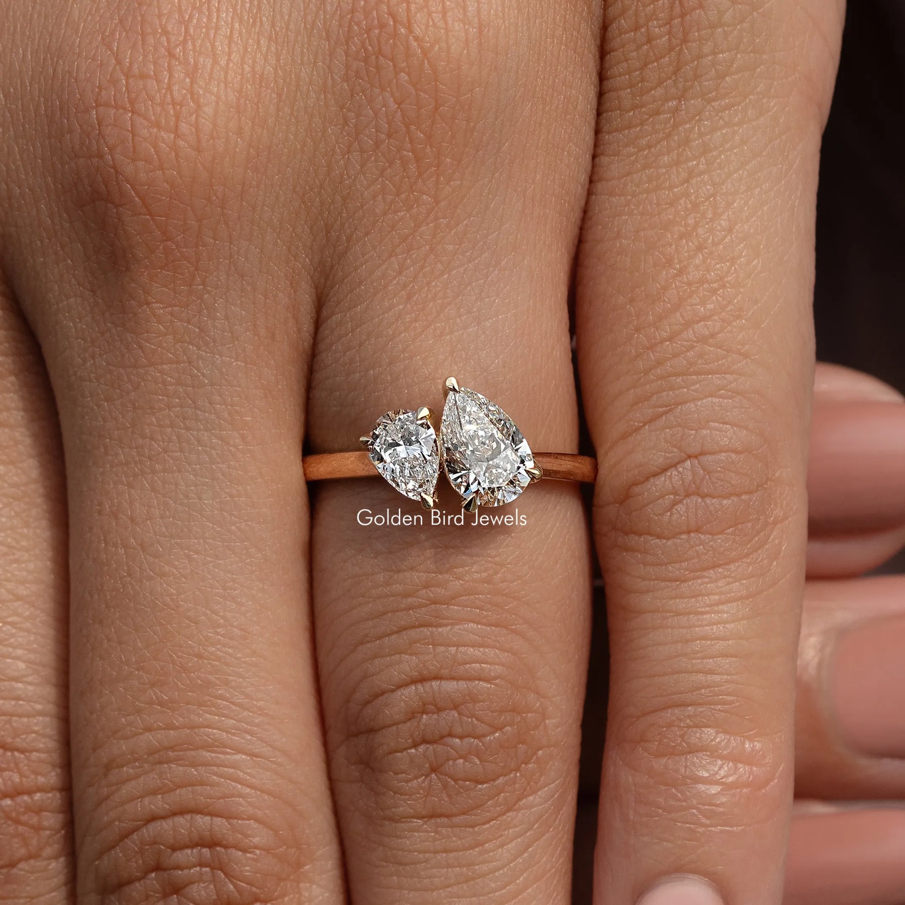 In finger front view of Pear Shaped Two Stone Ring in unique shape
