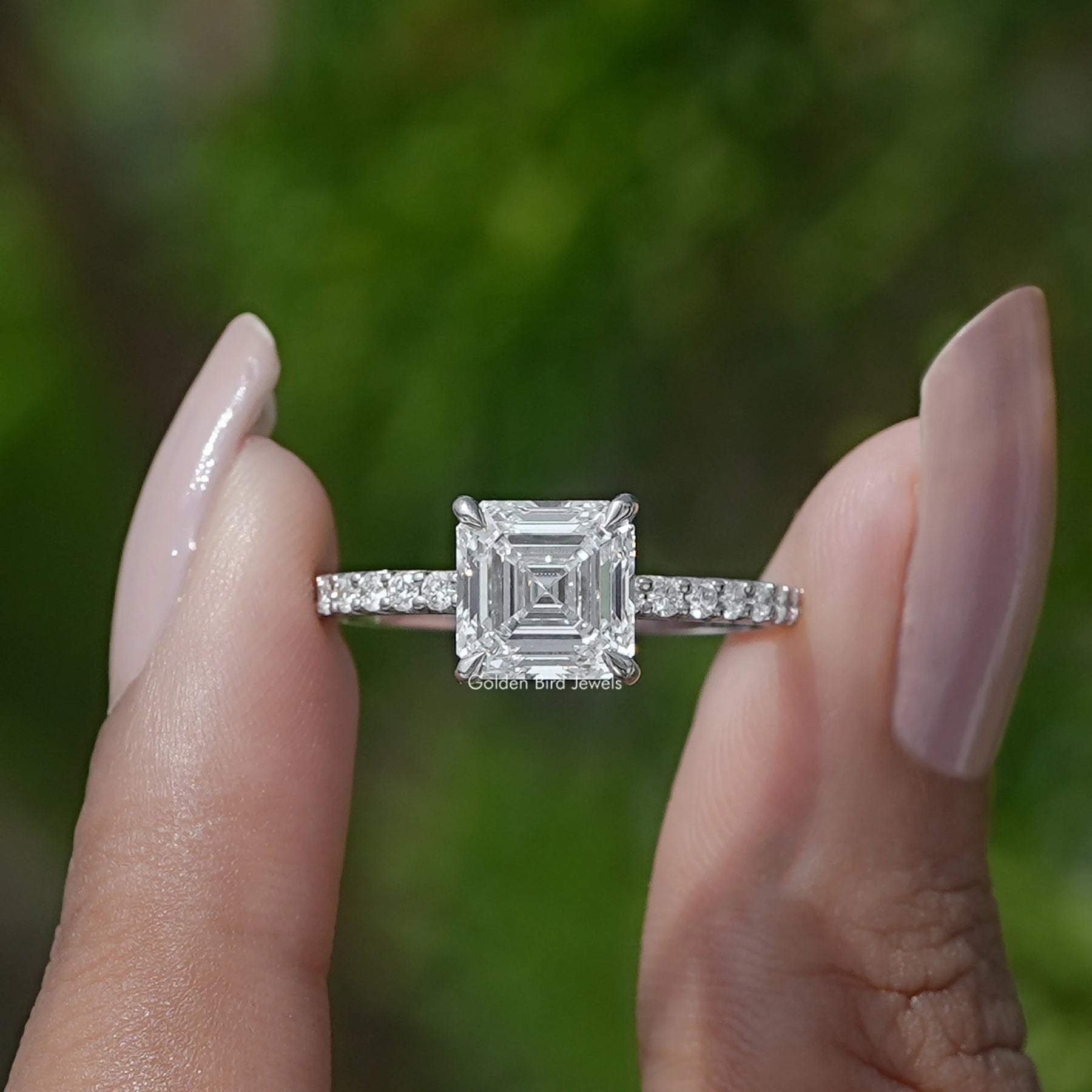 Front View of Emerald Cut Diamond Engagement Ring In two fingers