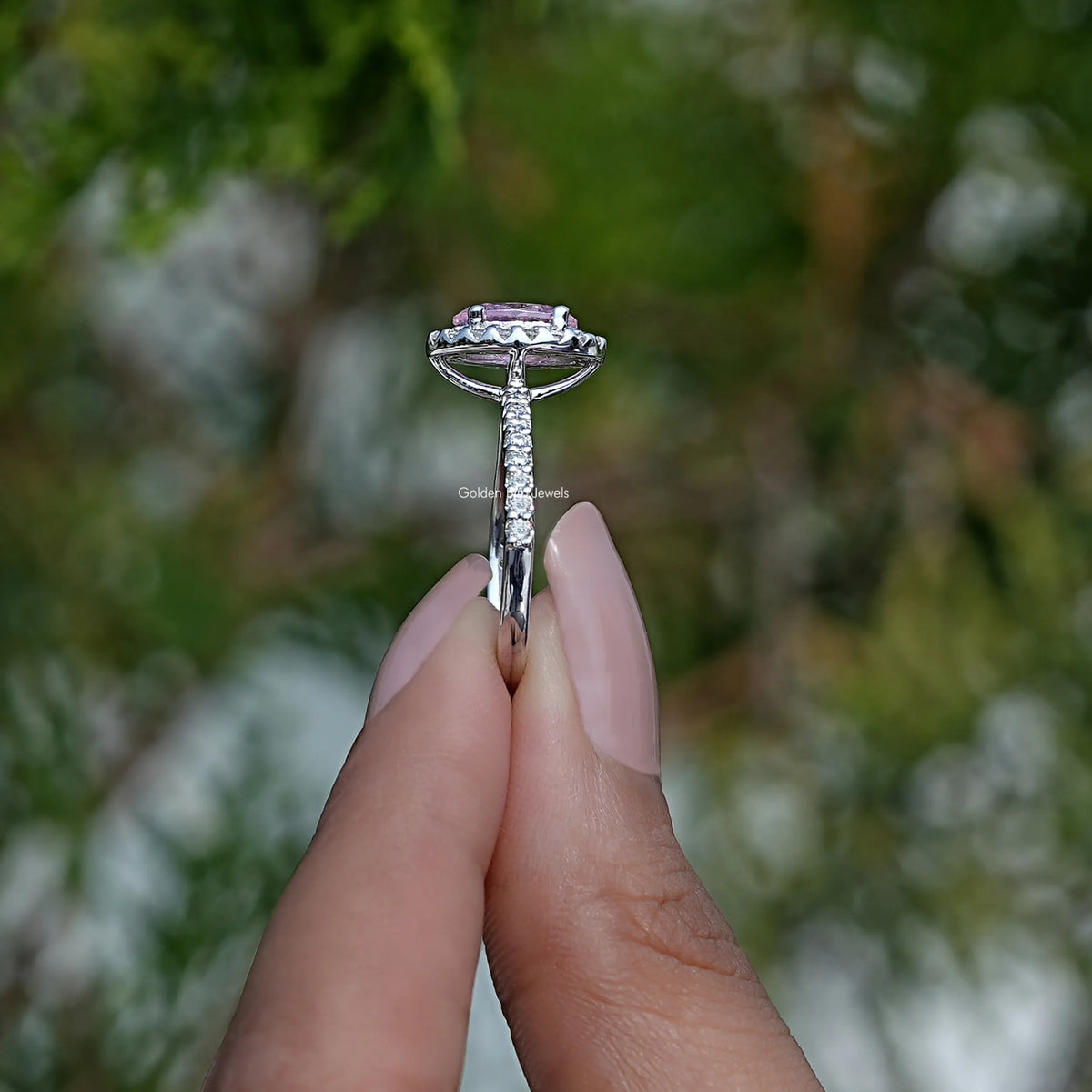 Side View of Oval Cut Engagement Ring In two fingers